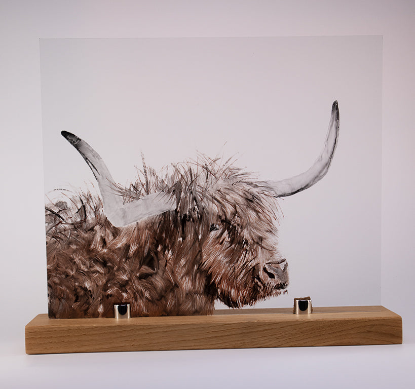 A stunning hand-painted masterpiece featuring a Highland Cow with long horns and shaggy fur on a wooden stand by LF Kaleidoscope. The artwork showcases detailed brushwork that beautifully and realistically captures the cow's textured coat. Mounted on a bespoke wooden base, this artwork creates a three-dimensional effect against a plain background.