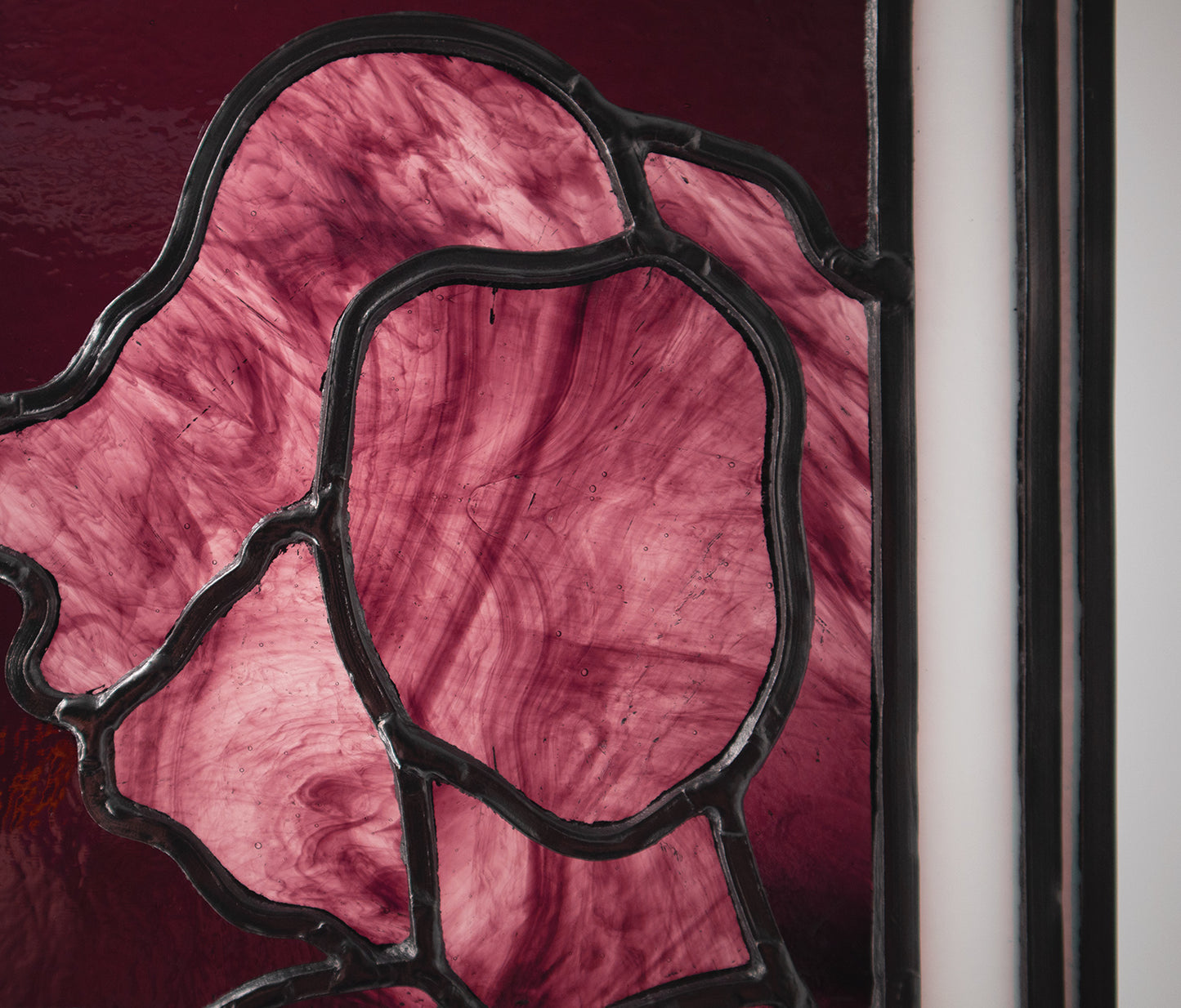 Alfreda, another example of LF Kaleidoscope’s Stained Glass Portraits. This stunning artwork captures the life model reflected in a bedroom window. Alfreda’s portrait showcases her flowing hair, and beautiful torso shapes rendered in deep red, luxuriant purples with the black lead lines creating structure and definition against the white glass window frame. Alfreda is staring through the window at you, and would look excellent in any house or gallery.