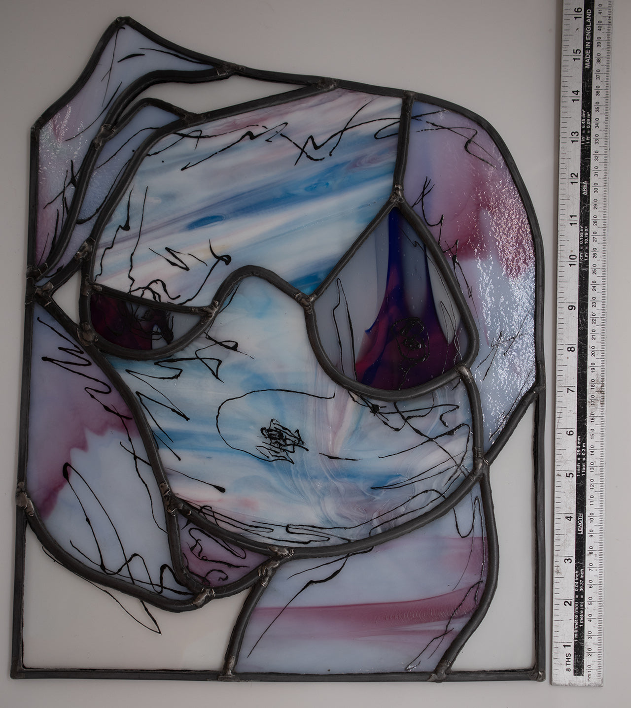 The Lily stained glass artwork, created by LF Kaleidoscope using rare Uroboros Glass, is a Personalized Glass Portrait of Lily capturing her curvacious nude body in magnificent white, pink and blue handmade glass, with extra glass painted calligraphy detail. It’s a great example of a freestanding luxury glass portrait for art collectors. 