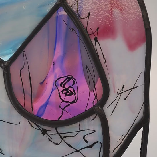 VIdeo showing The Lily stained glass artwork, created by LF Kaleidoscope using rare Uroboros Glass, is a Personalized Glass Portrait of Lily capturing her curvacious nude body in magnificent white, pink and blue handmade glass, with extra glass painted calligraphy detail. It’s a great example of a freestanding luxury glass portrait for art collectors. 