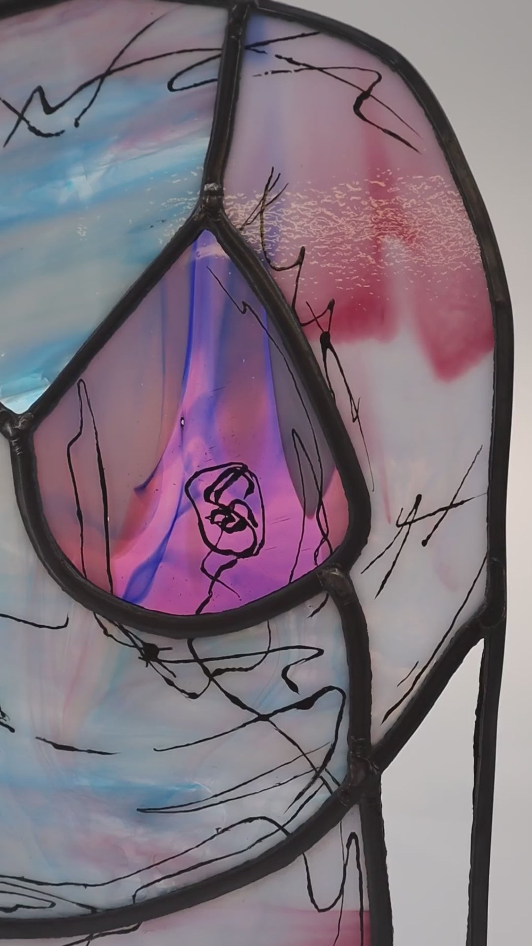 VIdeo showing The Lily stained glass artwork, created by LF Kaleidoscope using rare Uroboros Glass, is a Personalized Glass Portrait of Lily capturing her curvacious nude body in magnificent white, pink and blue handmade glass, with extra glass painted calligraphy detail. It’s a great example of a freestanding luxury glass portrait for art collectors. 